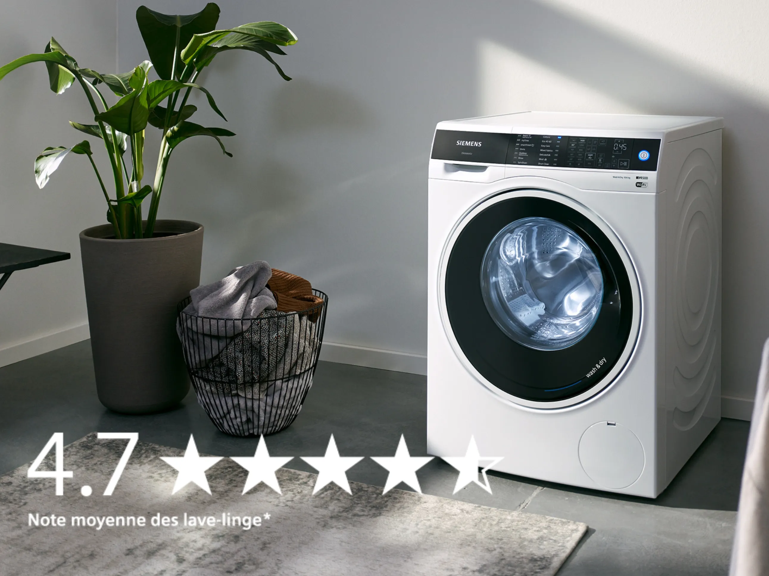 Machine à laver dans un intérieur moderne avec plantes et panier à linge.