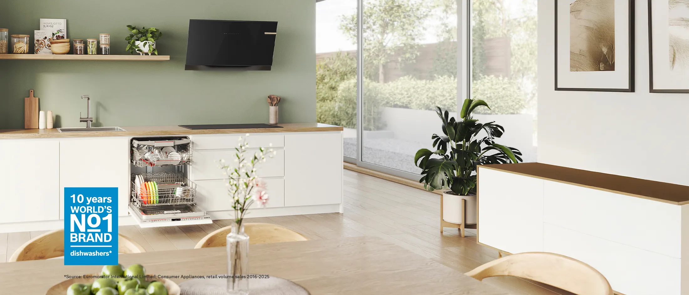 Bosch food processor with touch display surrounded by various fresh vegetables on a table.