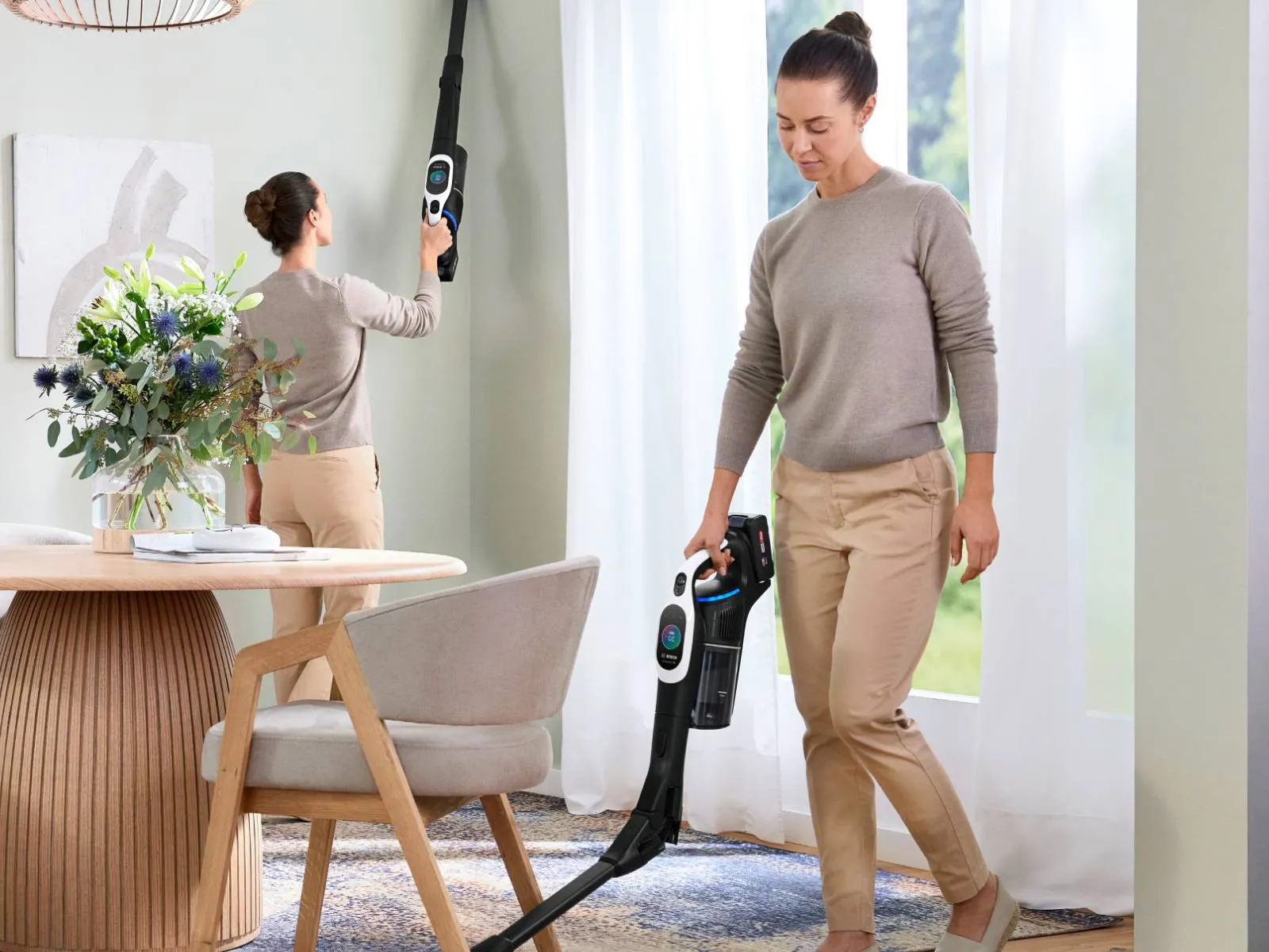 A woman uses a Bosch cordless vacuum cleaner in three different modes: as a handheld, for high reach, and as a stick vacuum, demonstrating its versatility in a modern dining room.