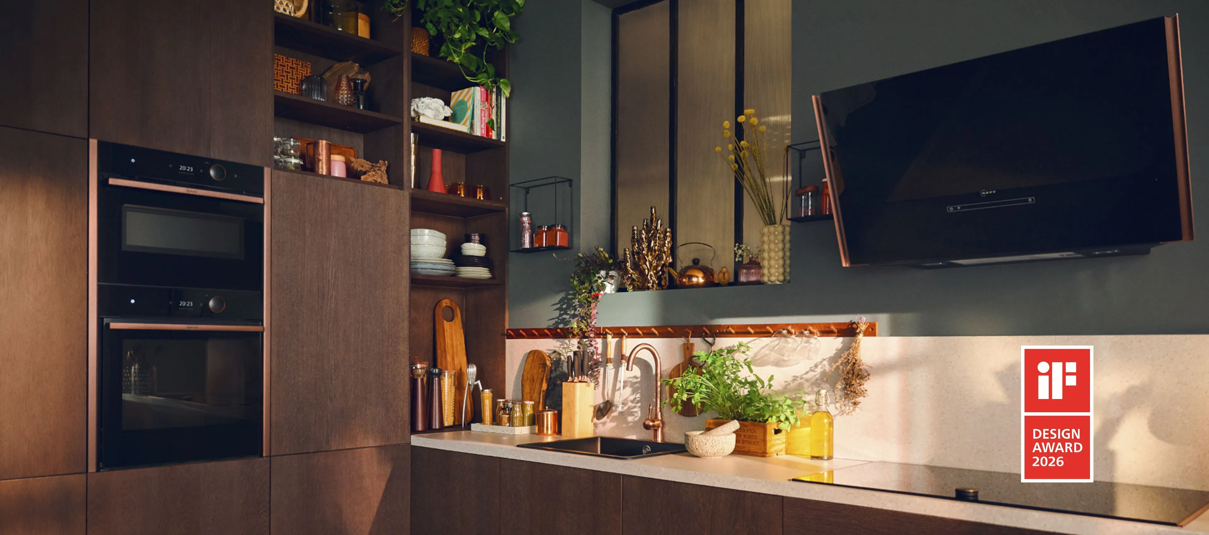 Μια κουζίνα με θερμά χρώματα και ξύλο, όπου διαθέτει οικιακές συσκευές NEFF.