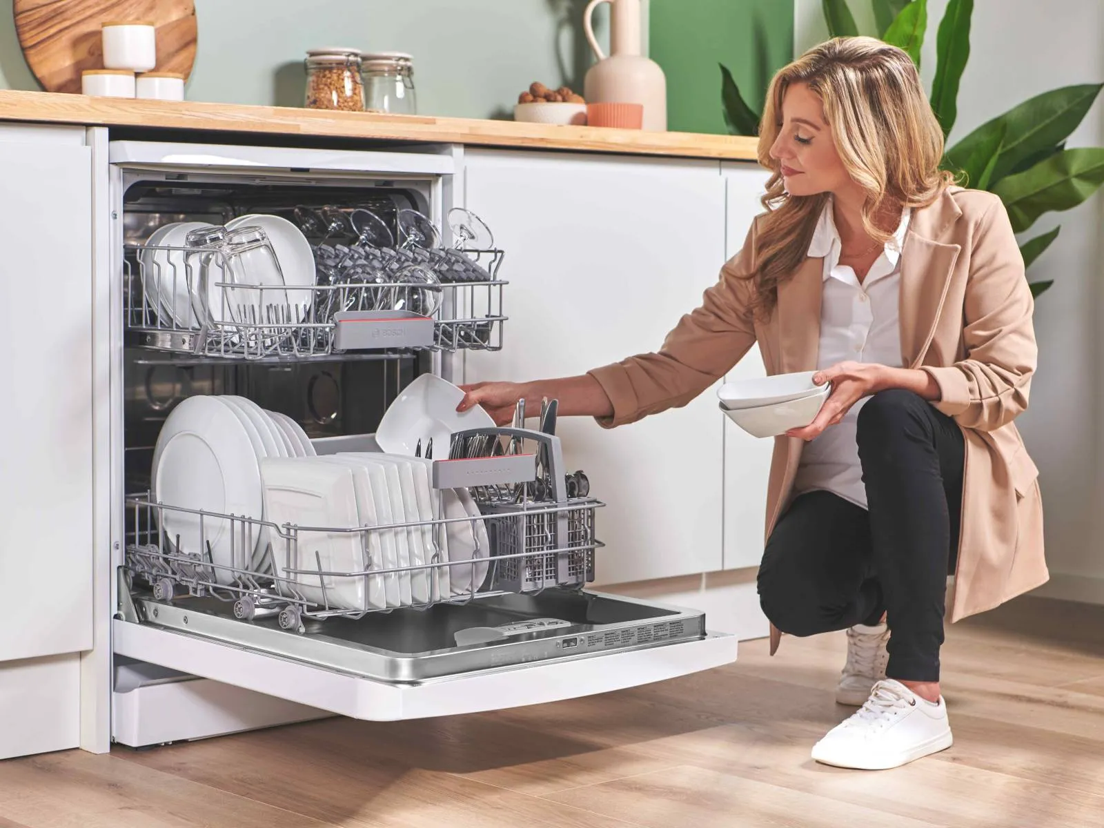 Person loading open dishwasher