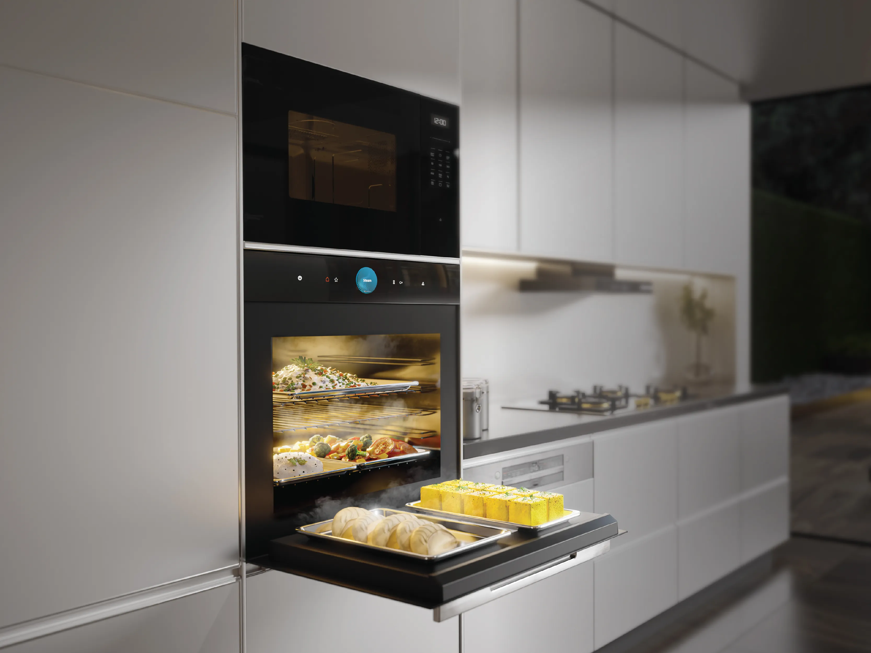 Built-in wall oven open with steaming trays of dumplings and yellow cakes on the pull-out tray and roasted dishes on interior racks in a sleek white kitchen.