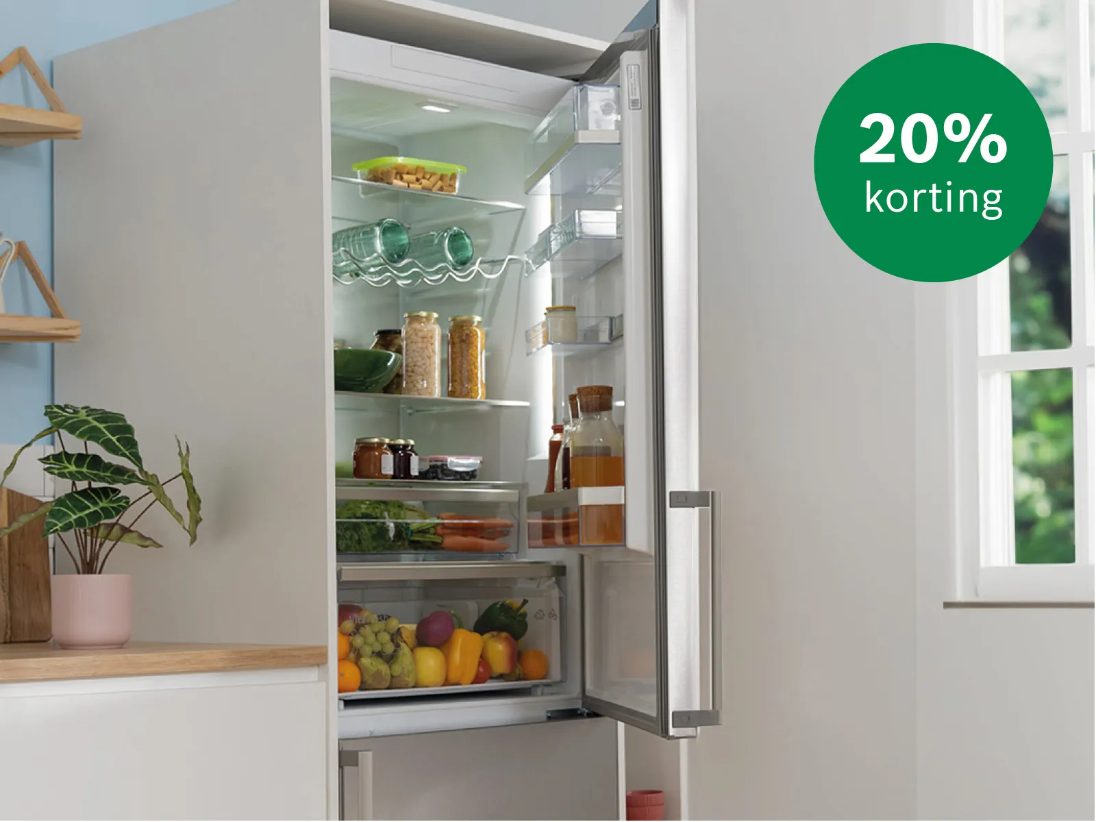 Koelkast die openstaat met voedingsmiddelen, flessenrekken en koelkastbakjes. 