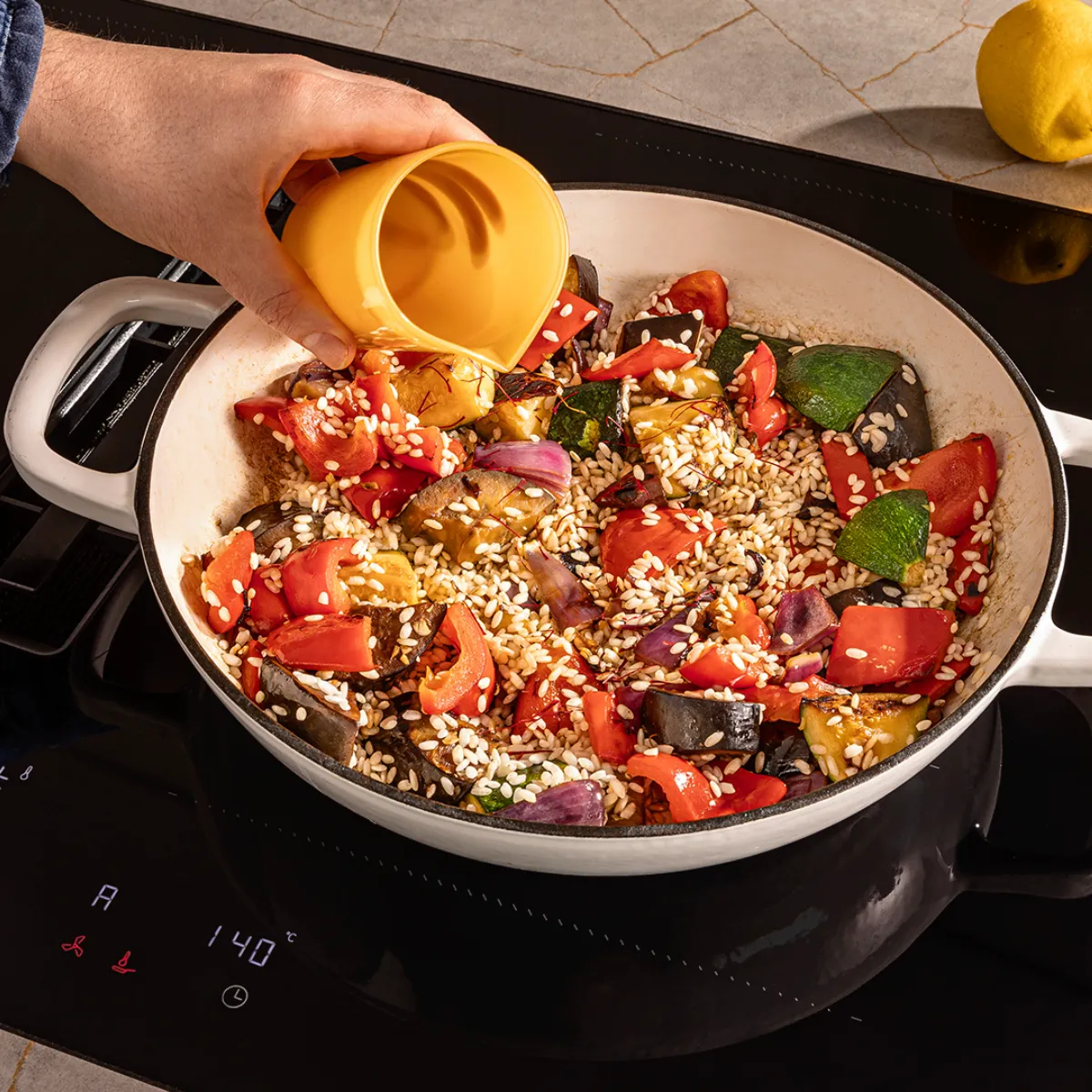 Cooking pan with quinoa, vegetables, and olive oil on a kitchen counter with additional ingredients.