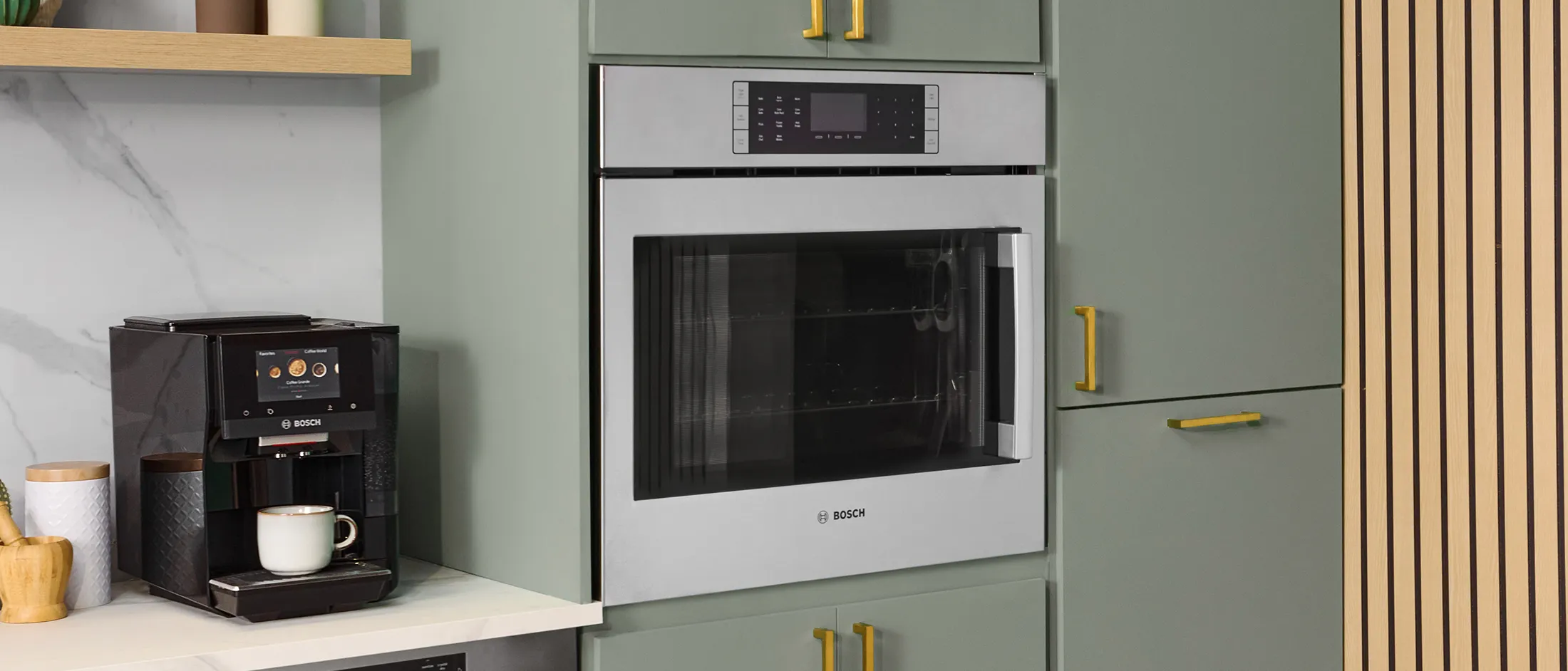 Cuisine moderne dotée d'une cuisinière au gaz, d'un four encastré Bosch, d'armoires minimalistes et d'un décor élégant, avec des limes fraîches et un livre de cuisine.
