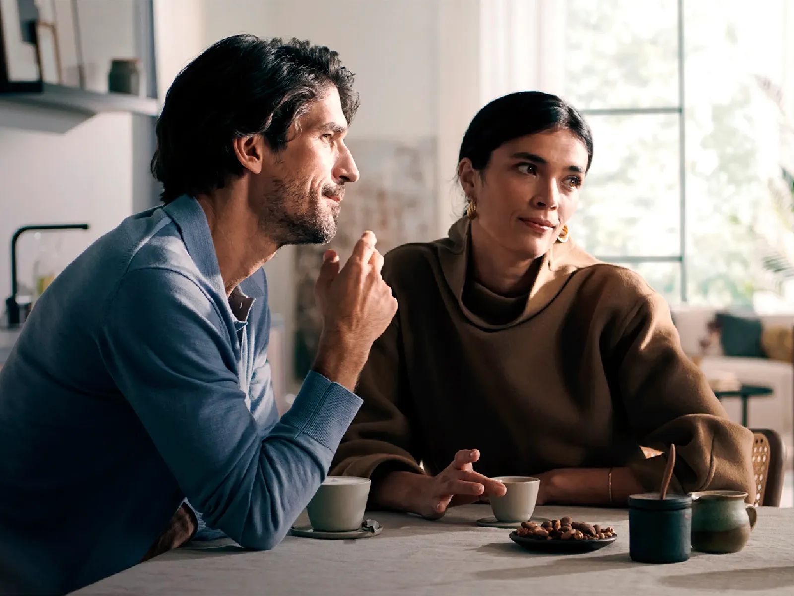 Two people enjoying coffee together in a modern kitchen, with a Siemens fully automatic coffee machine in the background.