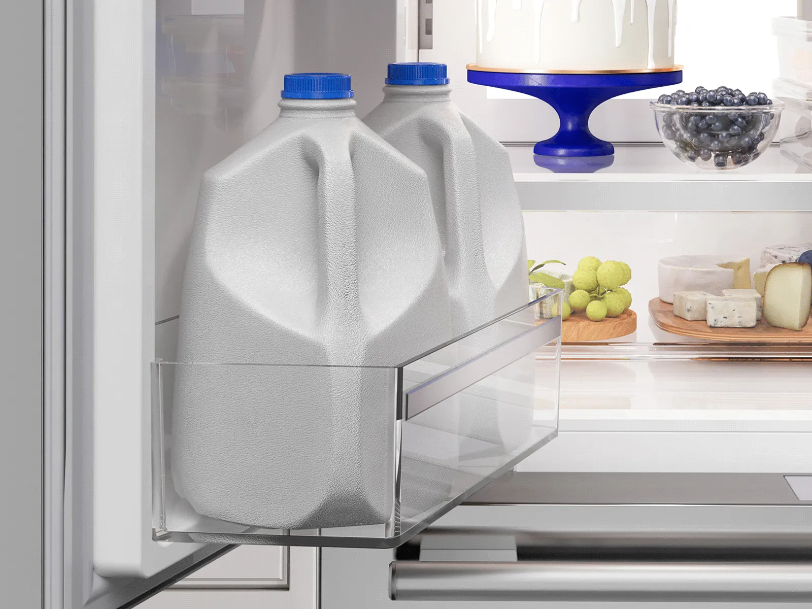 Close-up of a deep refrigerator door bin easily holding two gallon jugs of milk.