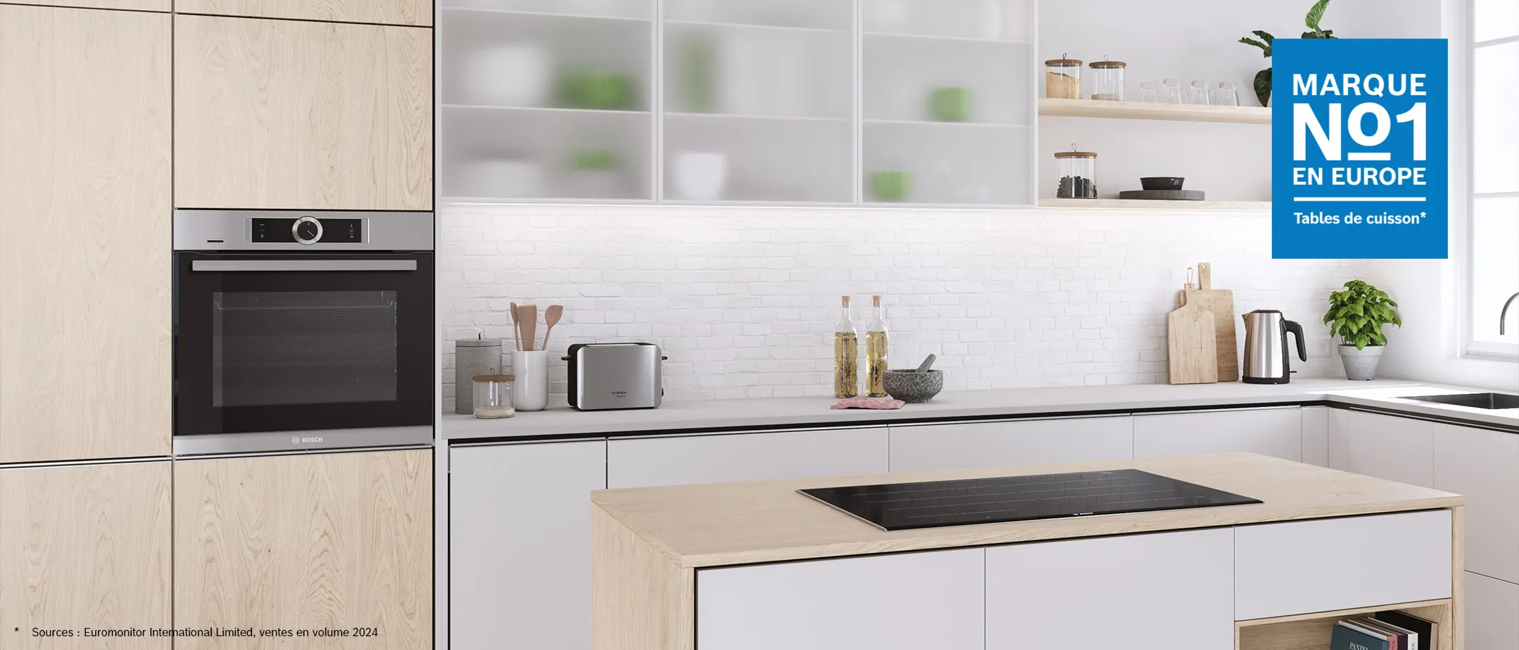 Un îlot avec une table à cuisson à induction dans une cuisine blanche et bois.