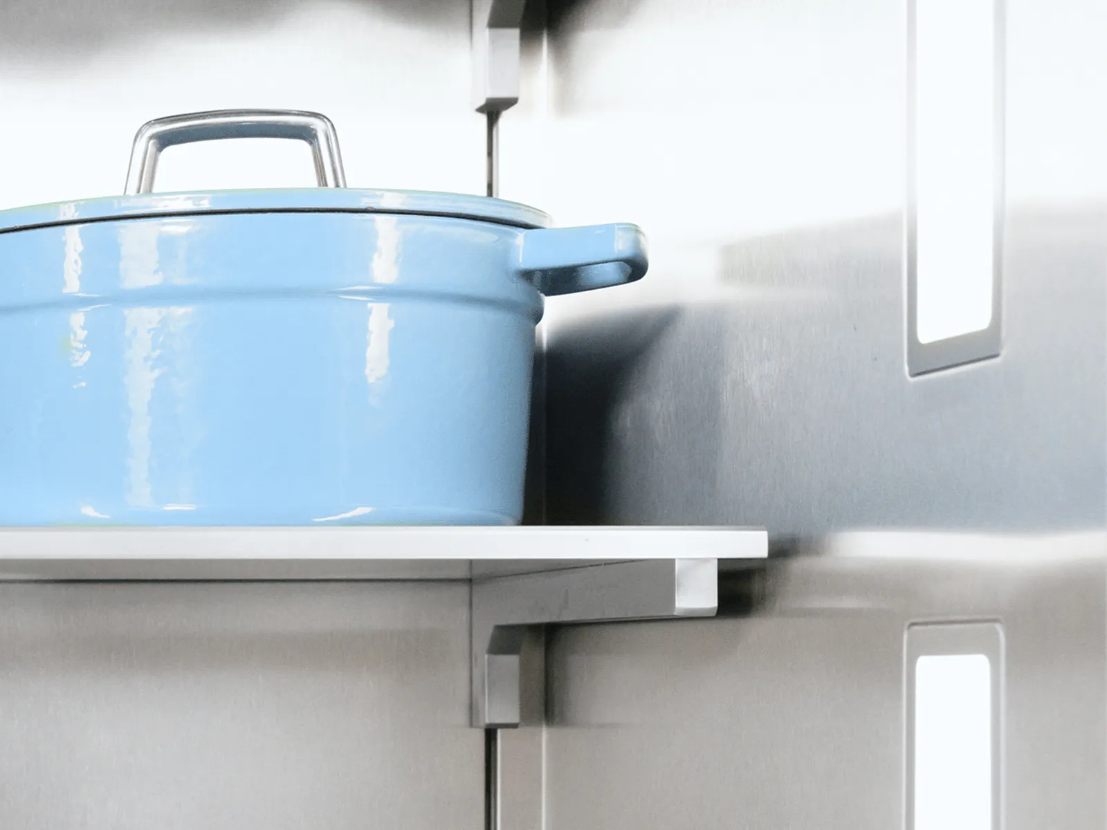Close-up inside a stainless-steel refrigerator showing a white shelf holding a light blue enameled pot with lid; vertical LED lights and reflective interior visible.