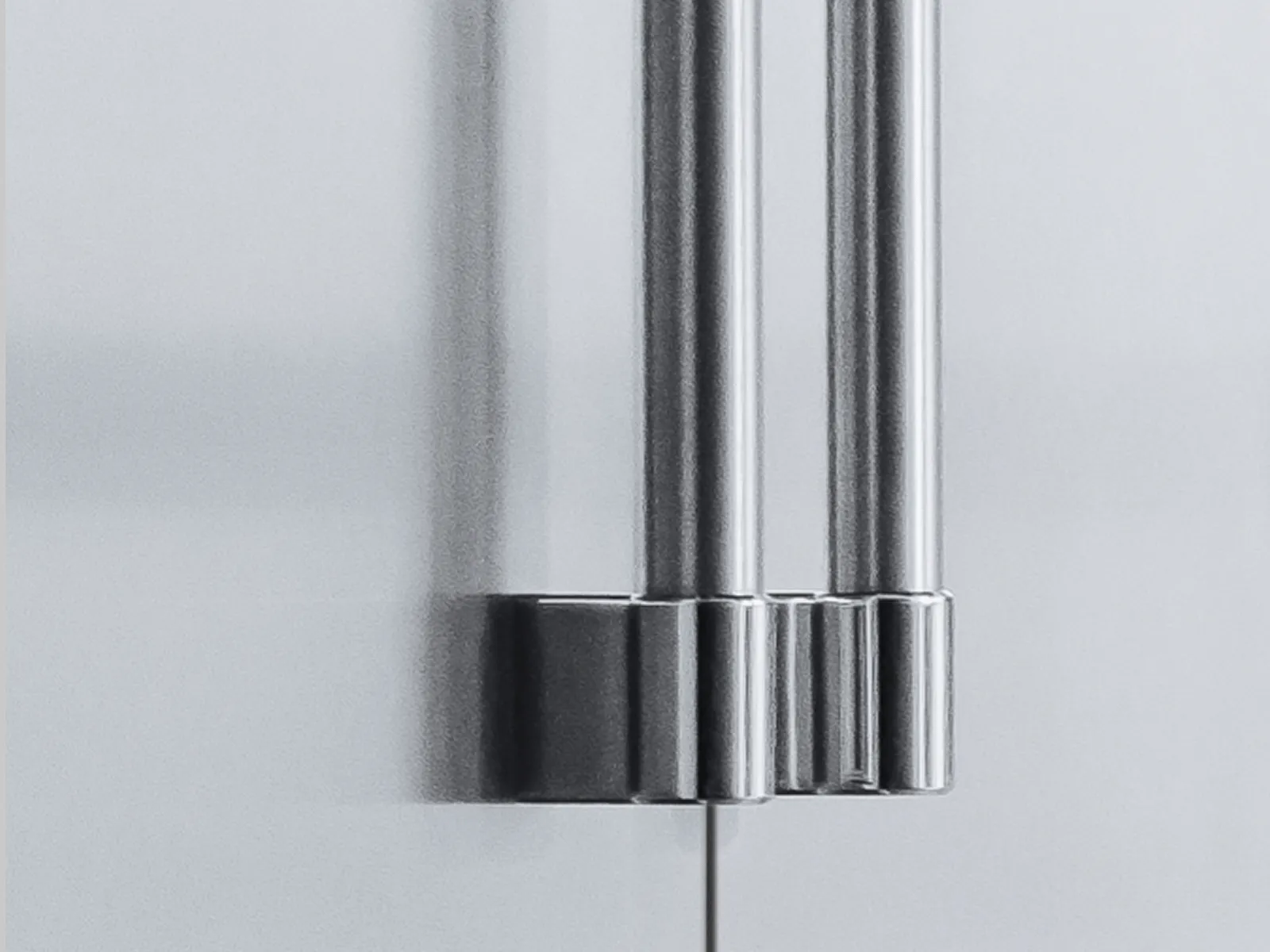 Close-up of a professional-style stainless steel refrigerator handle with a detailed base.
