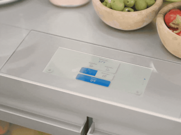 A finger taps the touchscreen control panel on a refrigerator to adjust the temperature.