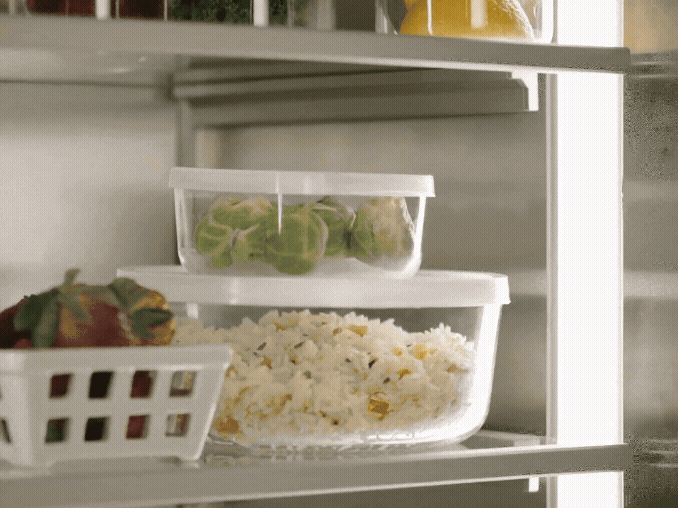 A freezer drawer showing organized storage for ice cream, pizzas, produce, and meats.