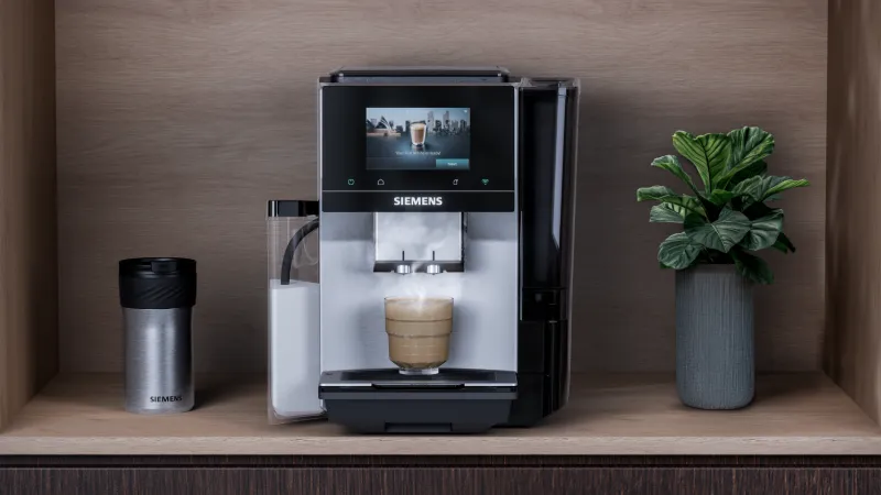 Siemens EQ700 iAroma fully automatic coffee machine with bewing a cappuccino on a counter.