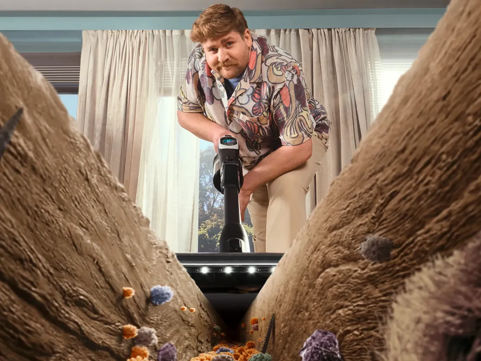 Person using a vacuum cleaner, viewed from inside the vacuum head aiming at dust, debris, and allergens on a carpet.