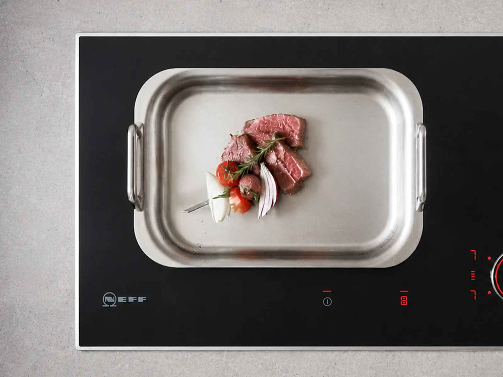 Stainless steel baking tray with fresh strawberries on a black electric stovetop.