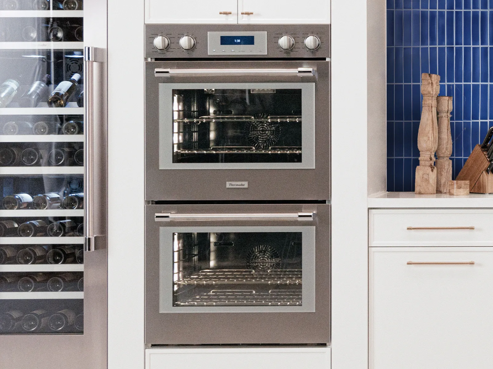 Stainless steel double wall oven with a wine cooler built into modern kitchen.
