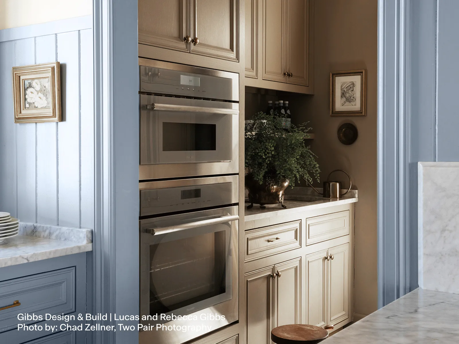 Modern kitchen with built-in double oven and wooden cabinetry in a stylish corner setting.