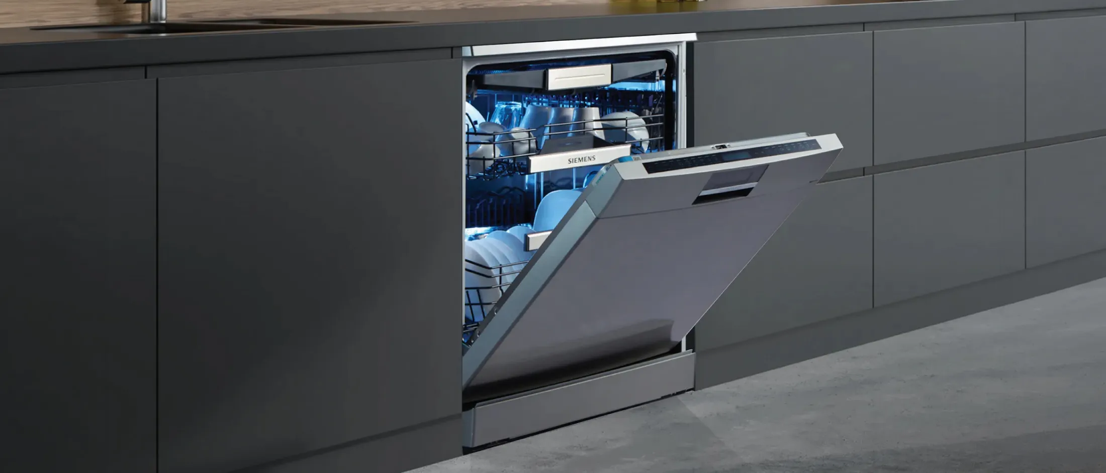 Modern kitchen with a Siemens dishwasher with elegant design, showcasing clean dishes inside, amidst a wooden cabinet backdrop.