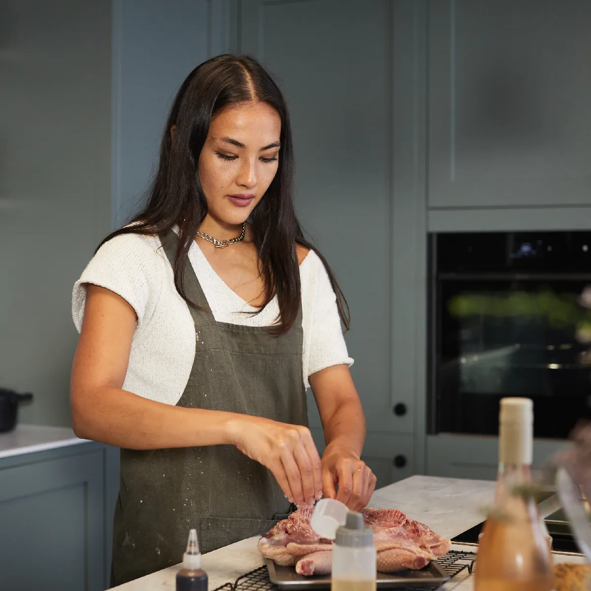 Femme en tablier préparant la nourriture dans la cuisine