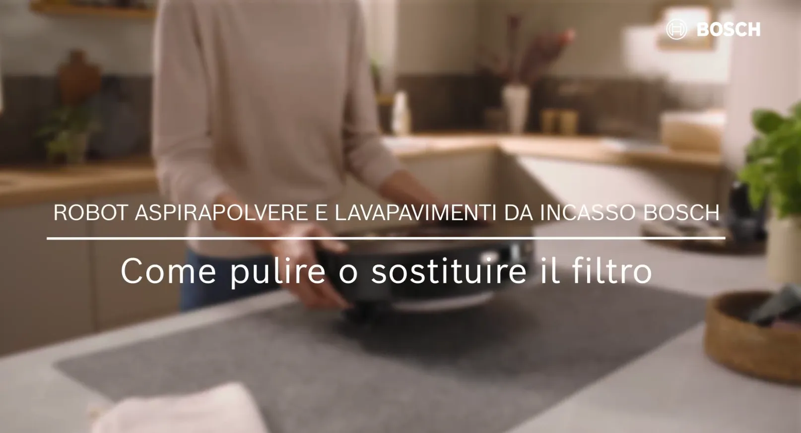 Persona che tiene in mano un robot aspirapolvere integrato Bosch in una cucina, con testo sulla pulizia o sostituzione del filtro.