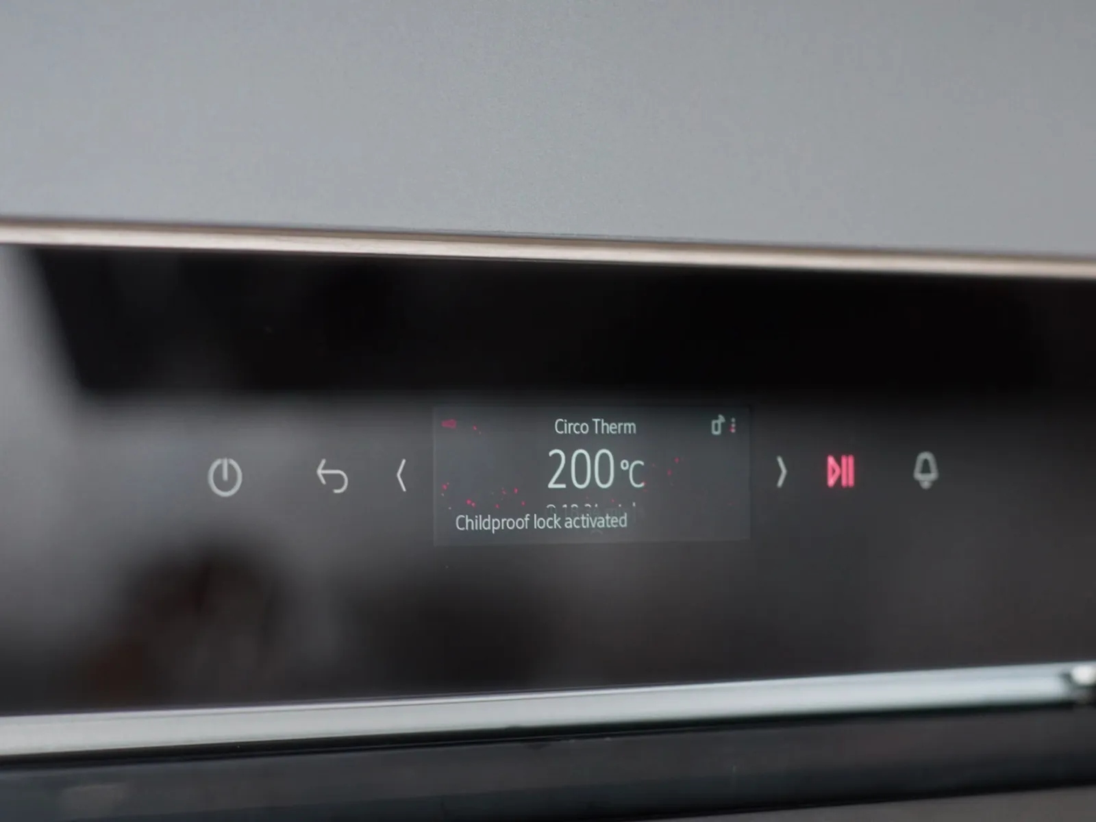 Close up of a slide and hide oven display, showing the Circo Therm and childproof lock being activated.