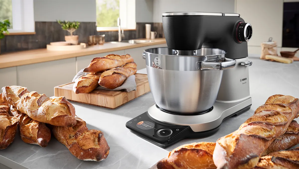 Bosch köksmaskin på bänk omgiven av nybakade baguetter i ett modernt kök.