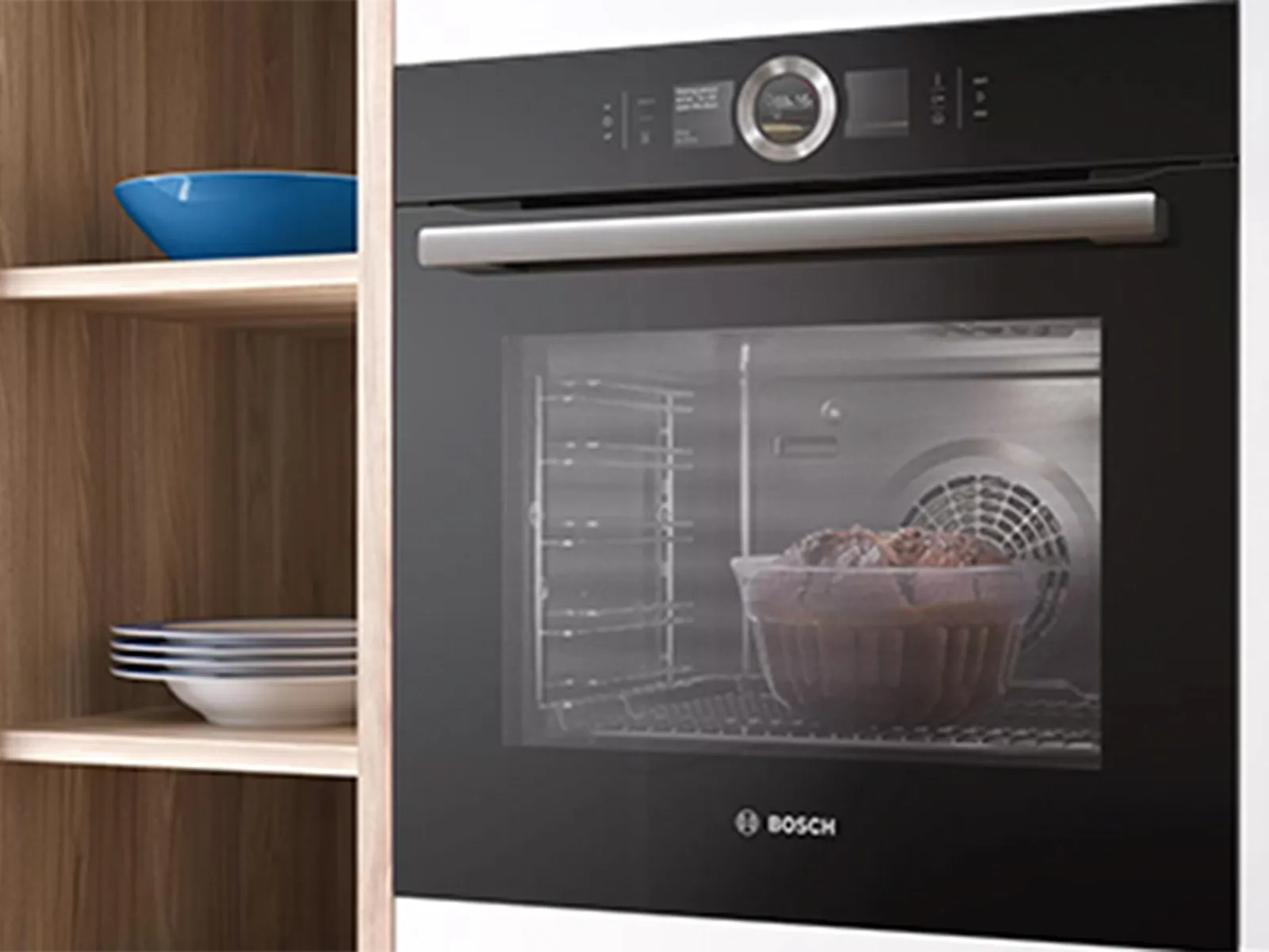 Modern kitchen with Bosch oven, wooden shelves, and blue ceramic bowl.