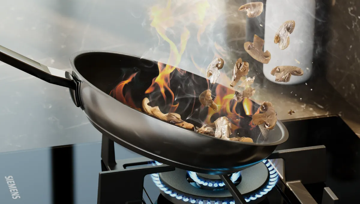 Skivade champinjoner som slängs och sauteras i en flammande wok på en gasbrännare.