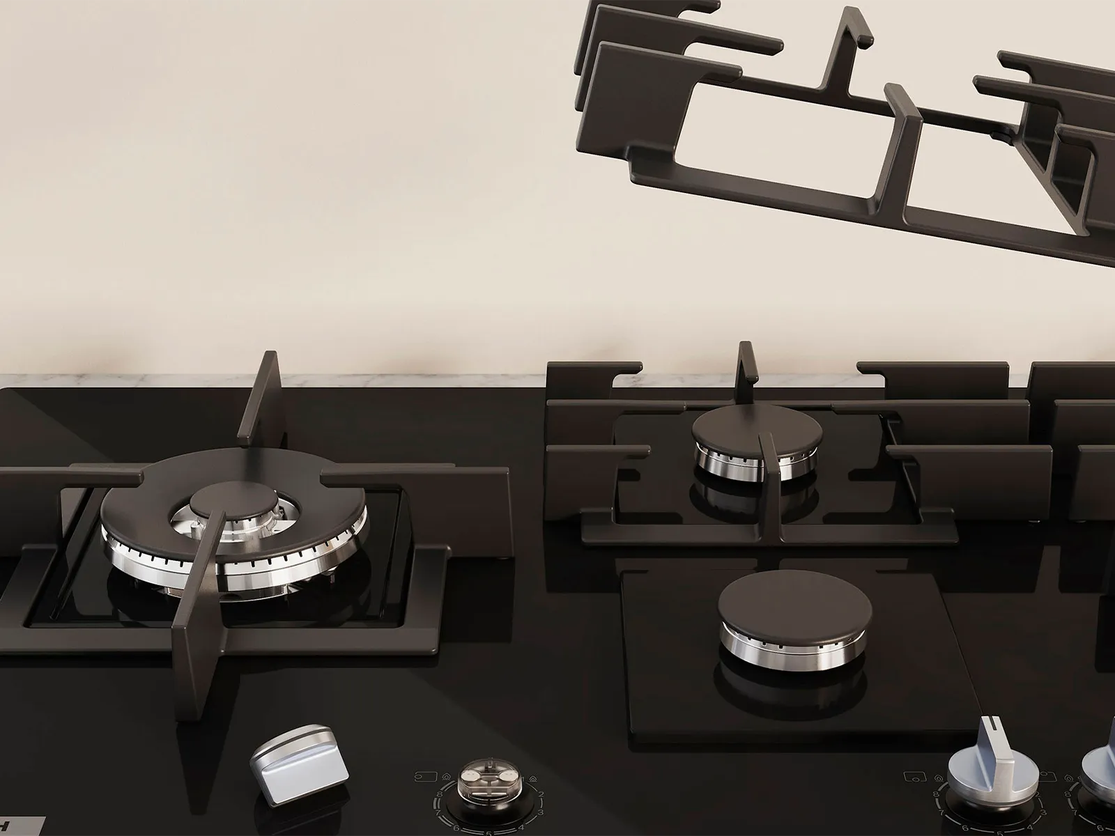 Close-up of a modern black Bosch gas stovetop with four burners and metallic control knobs.