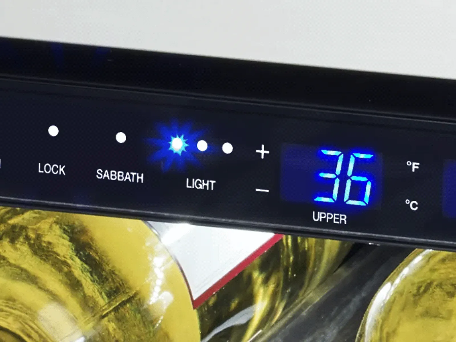 Close-up of a digital control panel on a wine cooler displaying temperature 36°F