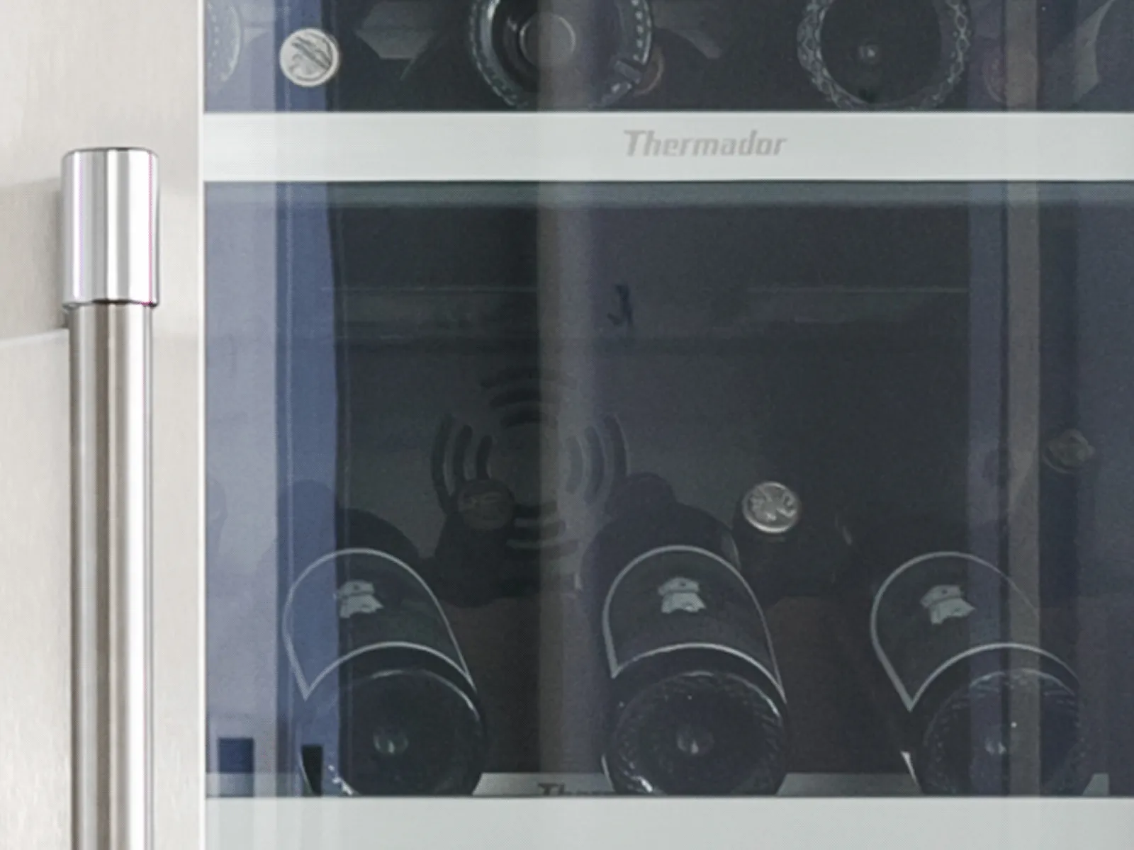Tall stainless-steel built-in wine refrigerator with a glass door and interior lighting