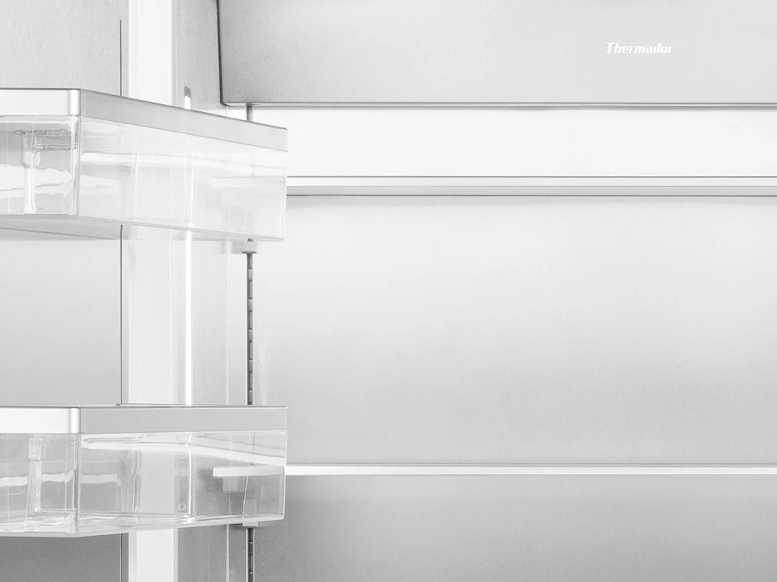 Grayscale close-up of an open stainless-steel refrigerator interior showing empty shelves, a digital control panel at the top, and clear plastic door bins
