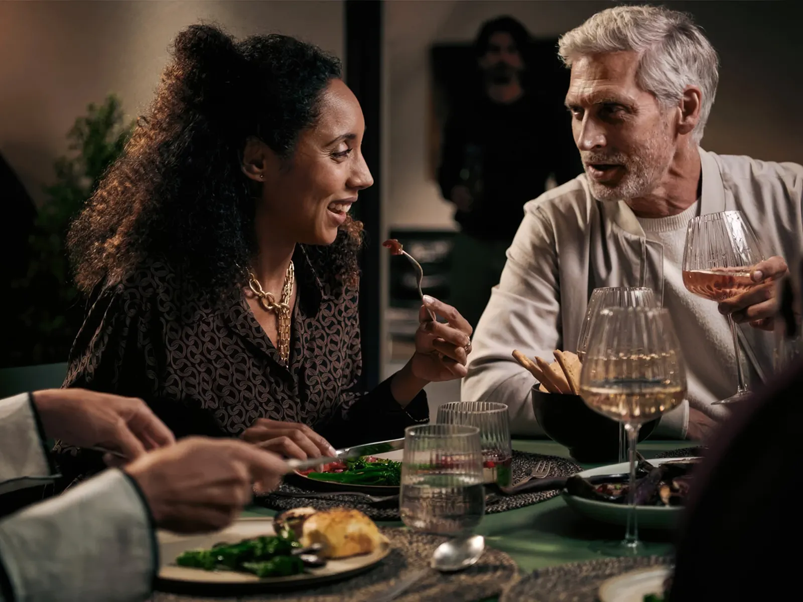 Two people having a conversation over a meal at a table.
