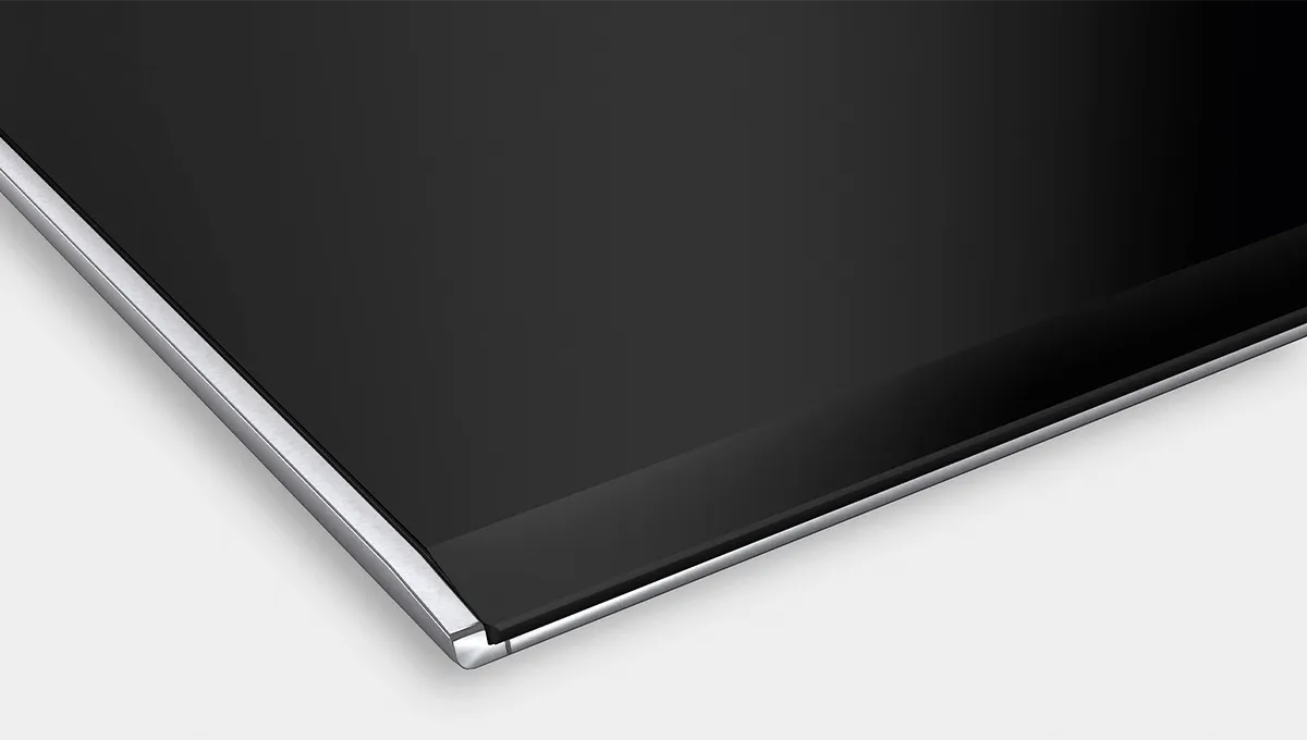 Primer plano de una superficie de encimera negra con un elegante borde metálico plateado alrededor de los bordes.