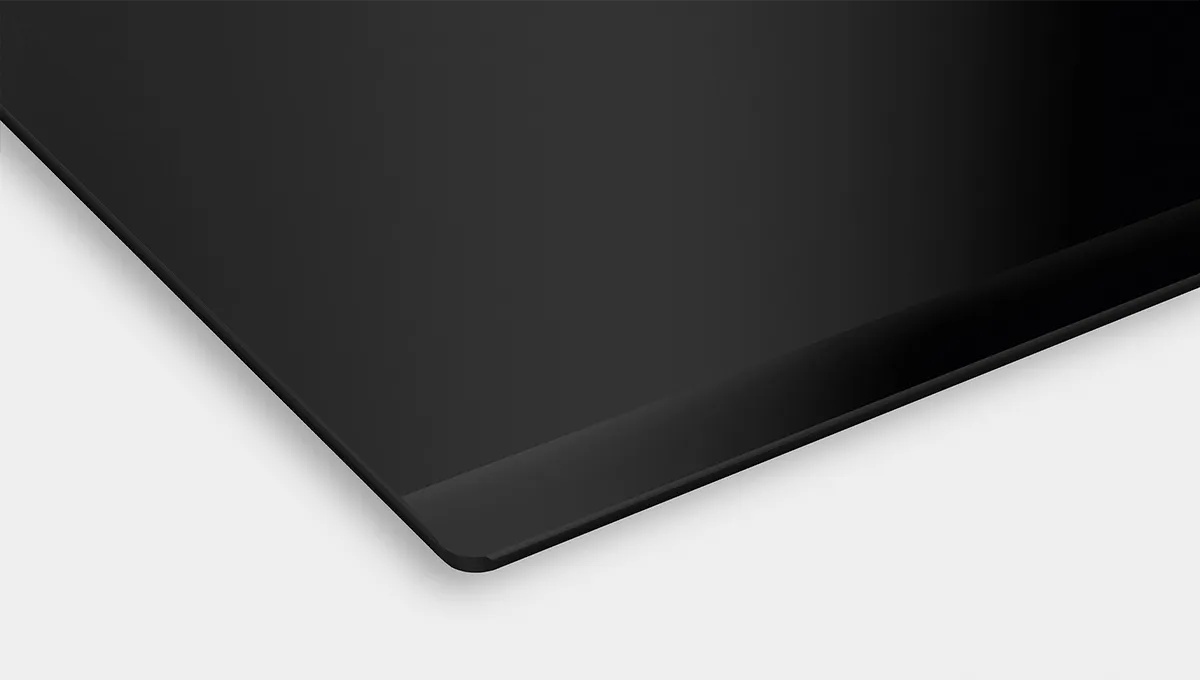 Encimera de inducción negra de Bosch con un elegante borde metálico a lo largo del borde frontal, mostrando su diseño moderno.