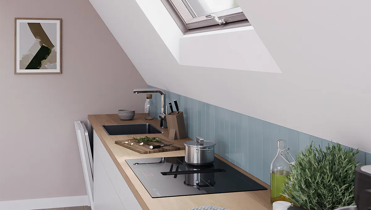 Encimera de inducción Bosch con extractor integrado en una cocina moderna con techo inclinado, tragaluz, fregadero y olla.