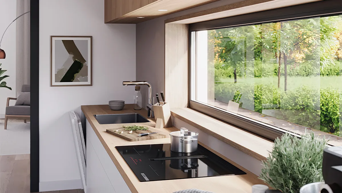 Encimera de inducción Bosch con extractor integrado en una cocina moderna. Una olla está sobre la encimera, junto a un fregadero y una gran ventana con vista al jardín.