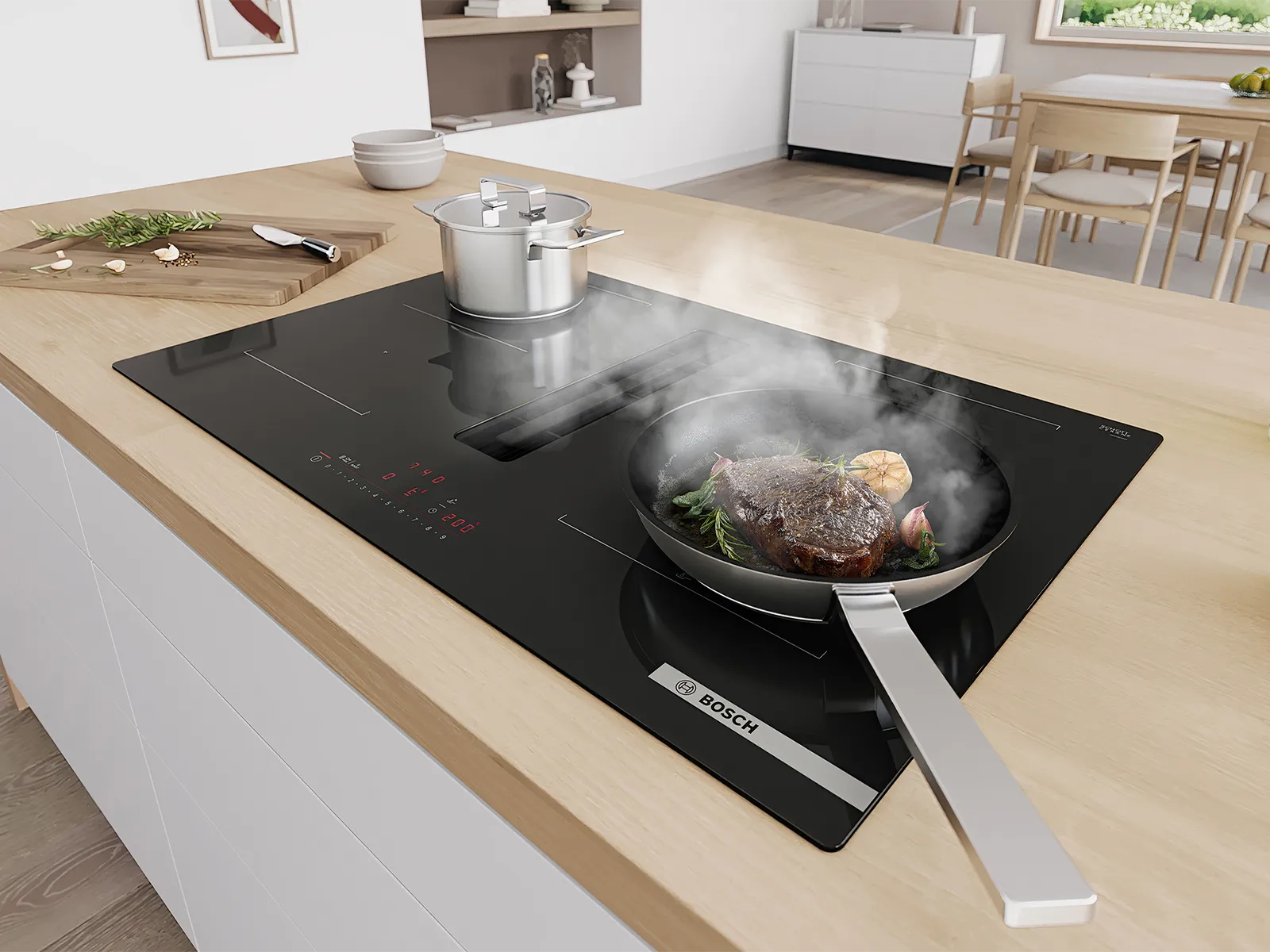 Encimera de inducción Bosch con extractor integrado, cocinando un bistec y una olla. El vapor del bistec al cocinarse es aspirado por el extractor en una cocina moderna.