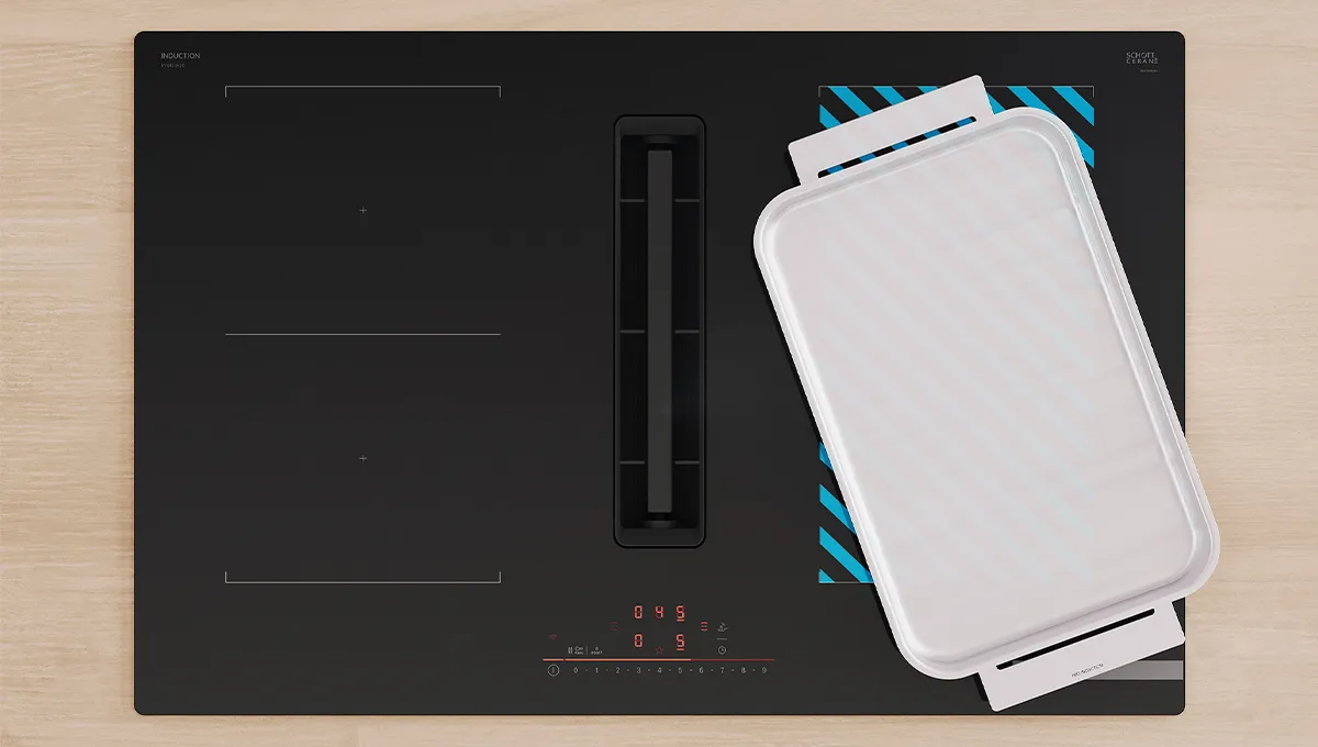 Encimera de inducción Bosch con extractor integrado. Una gran sartén rectangular blanca sobre una zona flexible activa, resaltada en azul.