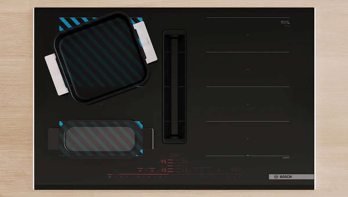 Encimera de inducción Bosch con extractor integrado. Dos zonas flexibles activas resaltadas en azul, una con una parrilla y otra con una sartén rectangular.