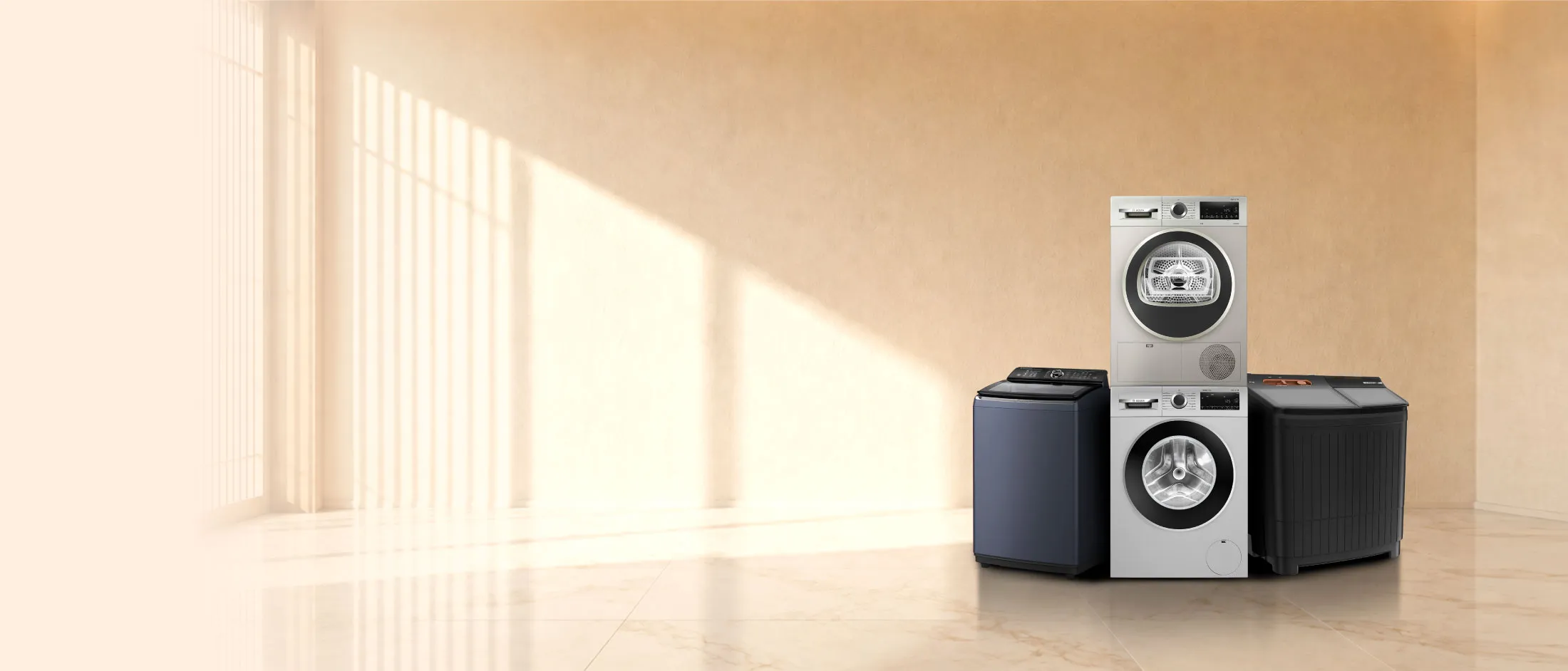 A washing machine and dryer stacked, surrounded by two other washing machines, in a room with warm lighting.