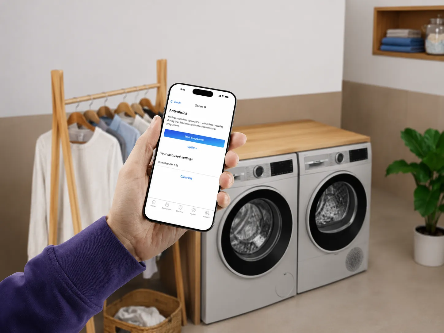 A person holds a smartphone displaying an app for adding laundry detergent.