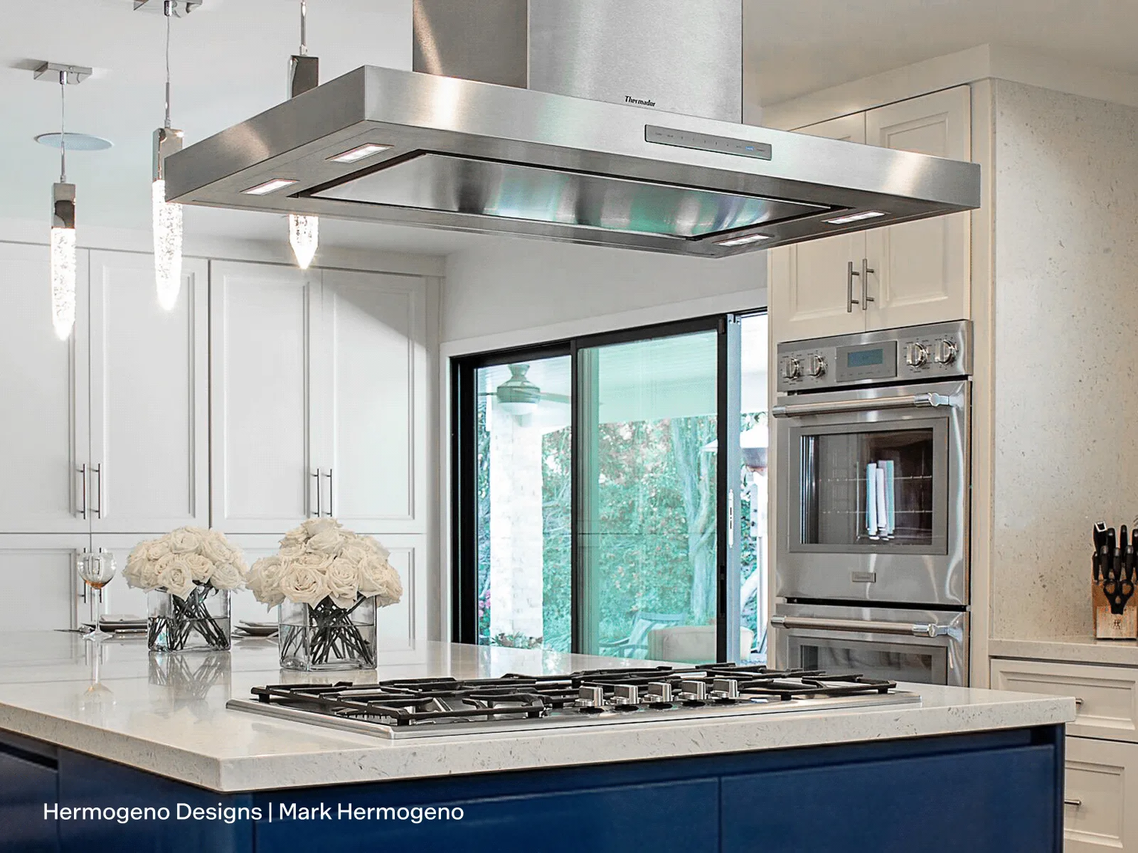 Thermador 42-inch Masterpiece island hood above a rangetop in a luxury kitchen.