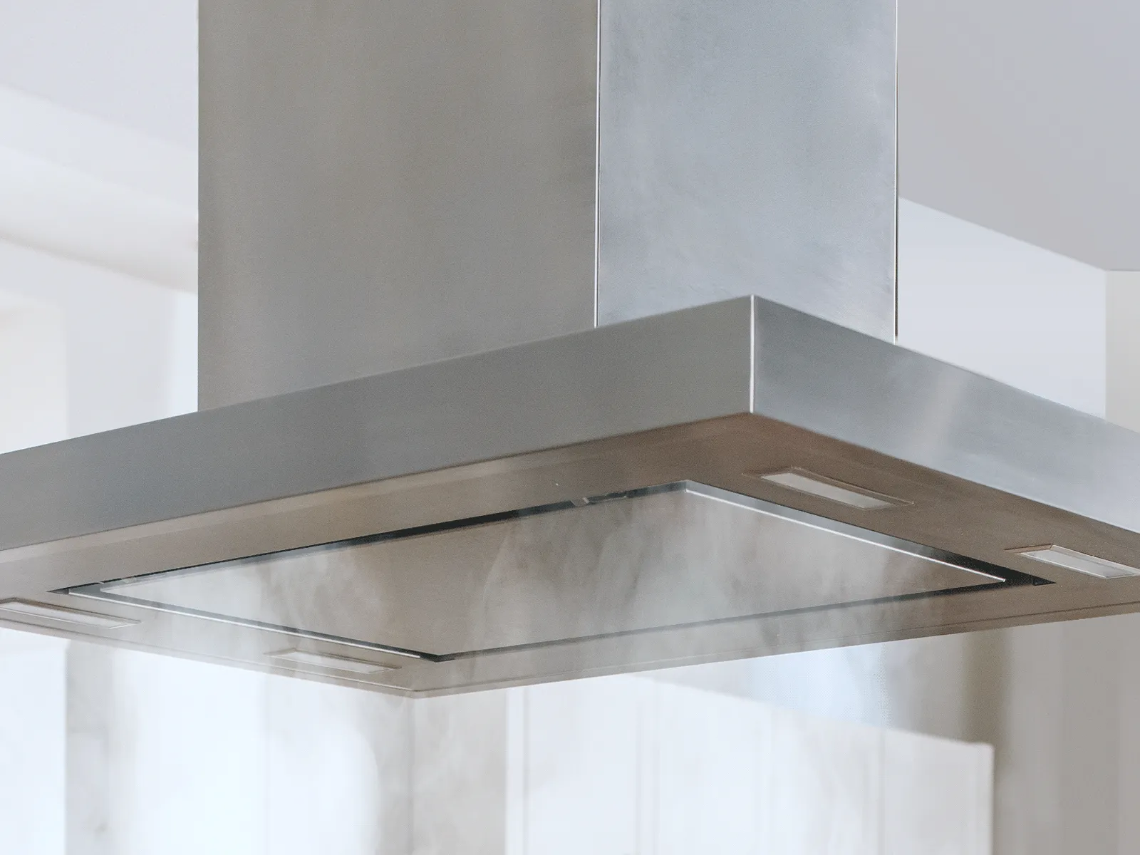A 42-inch Thermador island hood effectively capturing smoke while cooking.