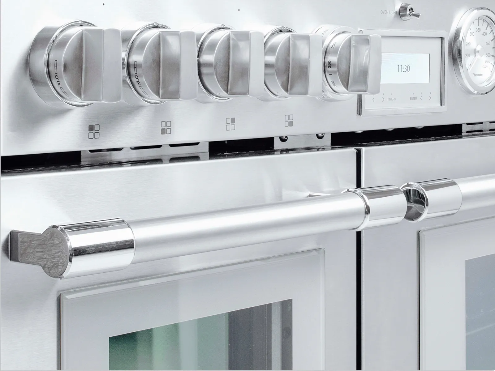 Stainless-steel range front with control knobs, digital display, and oven door handle.