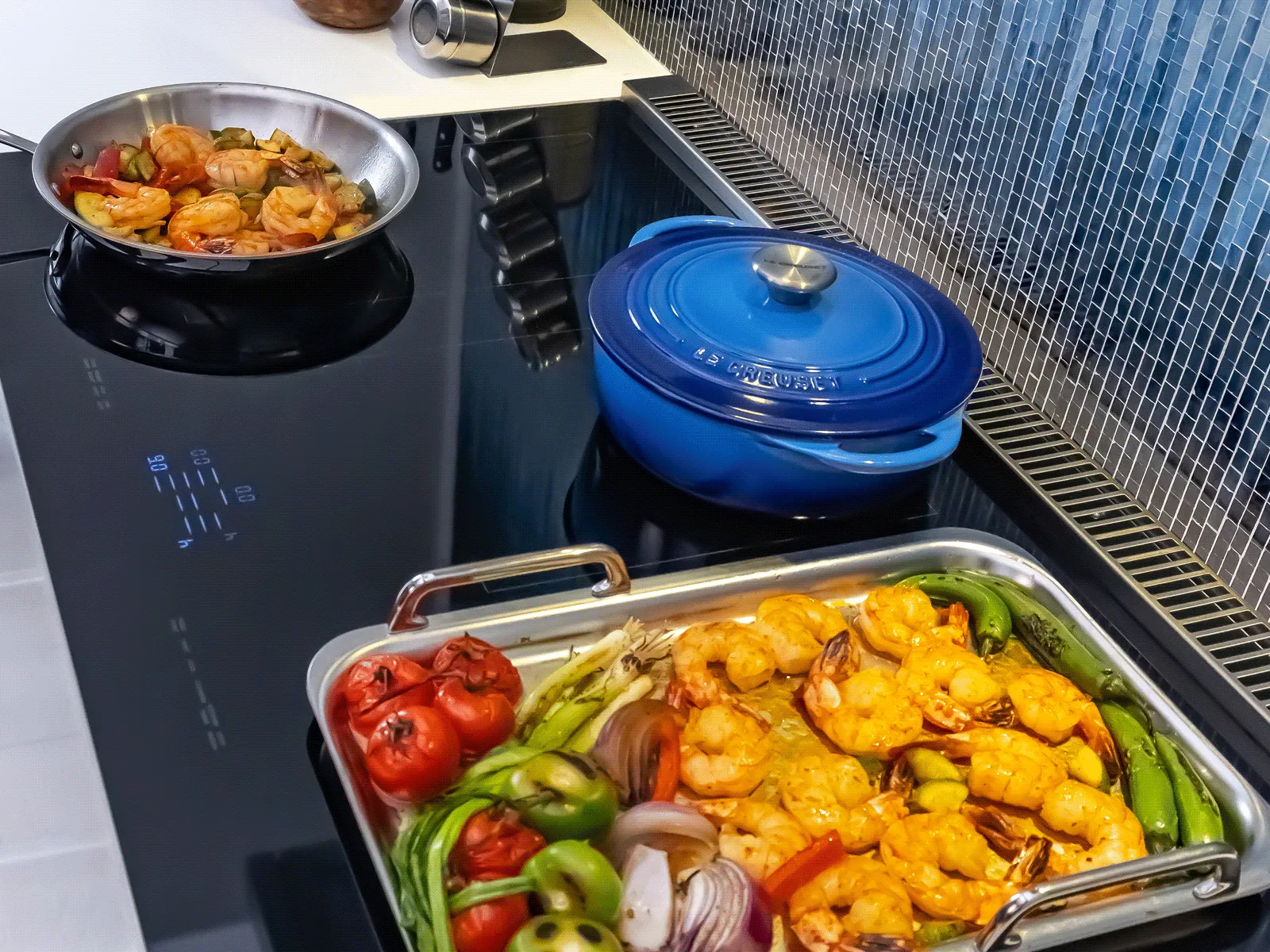 Up view of colourful vegetables and shrimps sitting on Thermador cooktop.