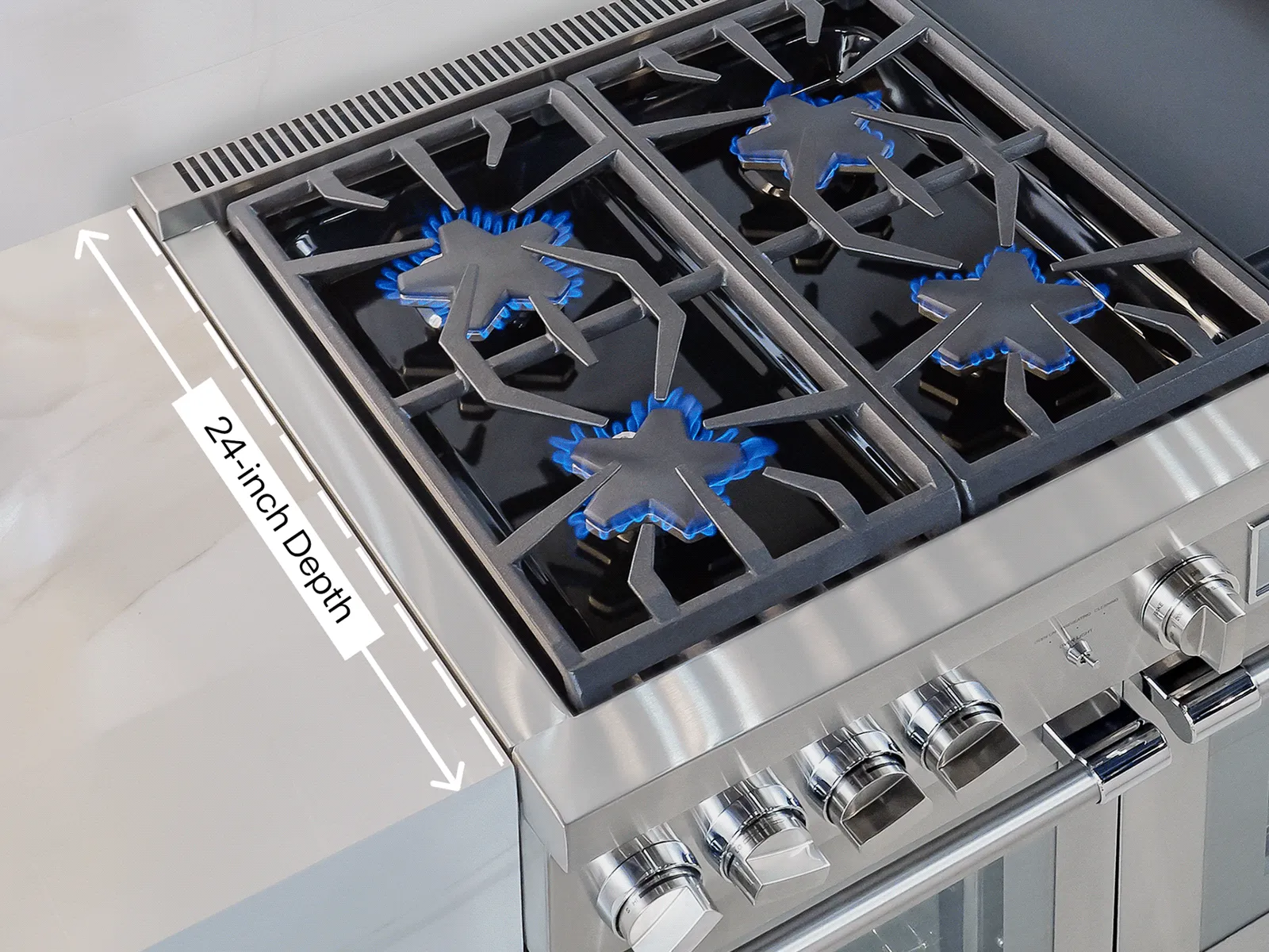 Stainless-steel gas cooktop with four blue-flame burners lit and a labeled "24-inch depth" measurement arrow.