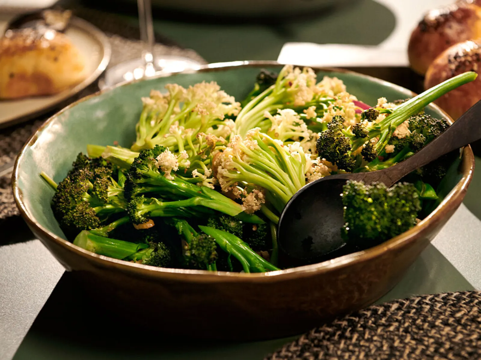 Immagine di una ciotola di broccoli cotti al vapore su un tavolo da pranzo.