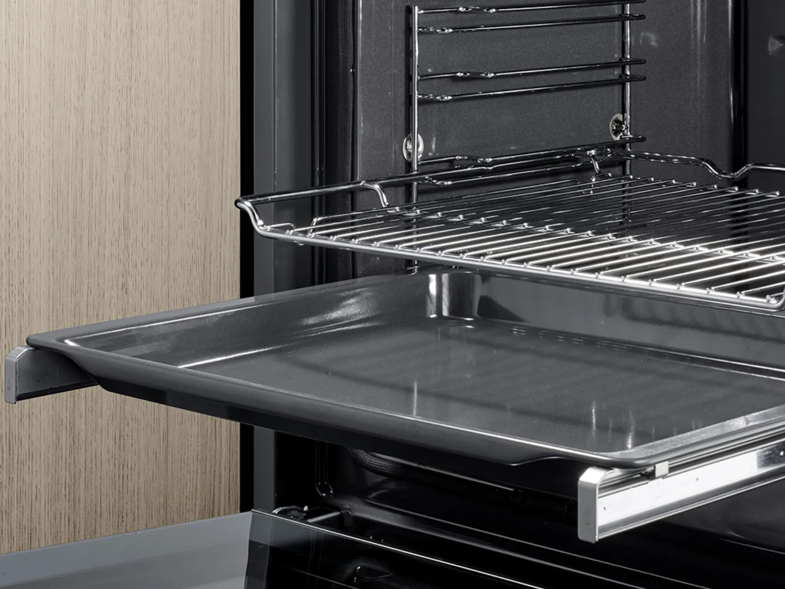 Immagine di un forno Siemens aperto con due teglie parzialmente estratte, che dimostra la flessibilità delle guide telescopiche.