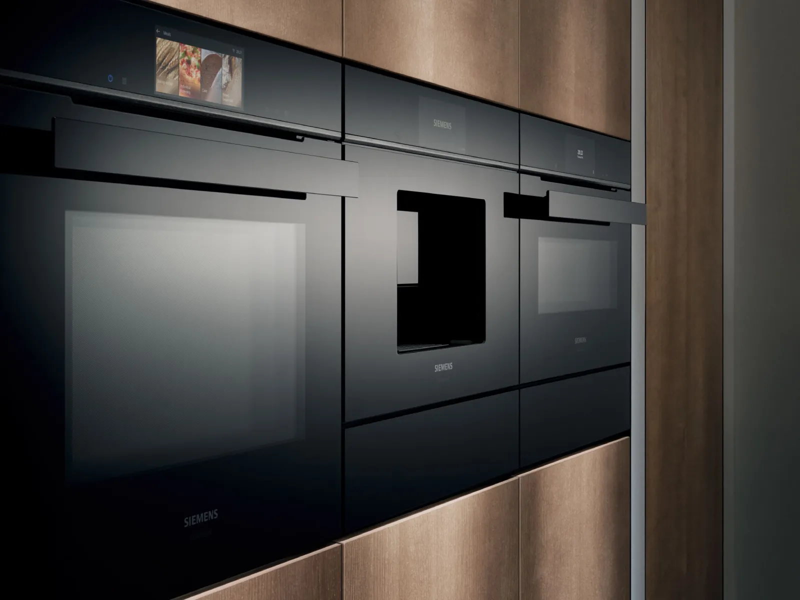 Vista laterale dello schienale di una cucina con vari elettrodomestici della serie iQ700, tra cui forno, microonde e vaporiera
